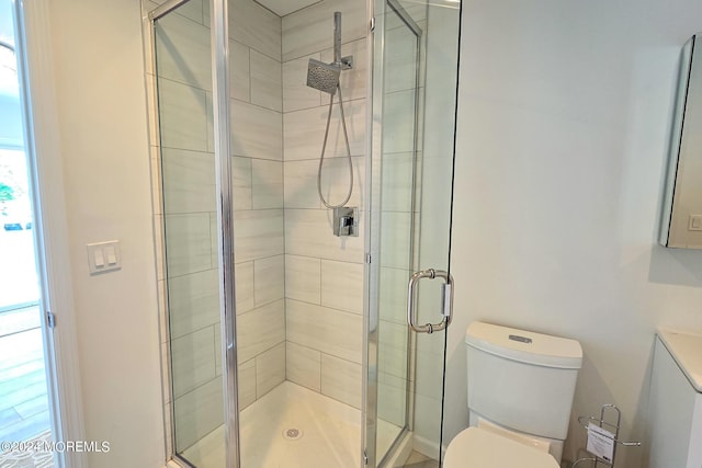 bathroom featuring toilet and a shower with door