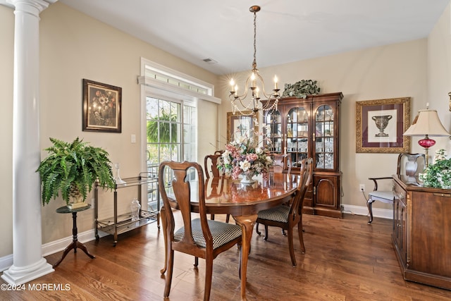 dining room featuring decorative columns, dark hardwood / wood-style floors, and a notable chandelier