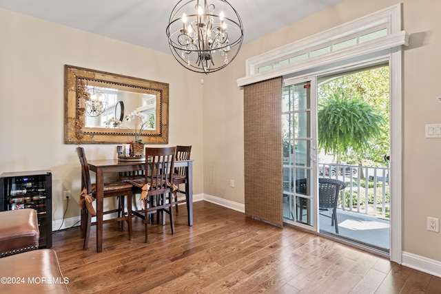 dining room with beverage cooler, wood-type flooring, and a notable chandelier