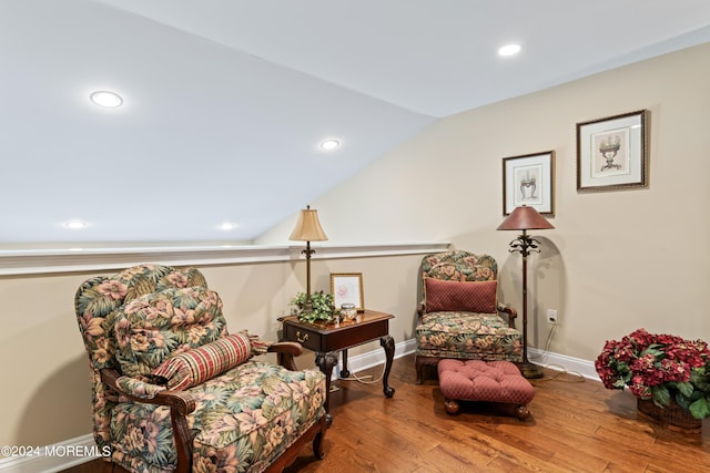 sitting room with hardwood / wood-style floors and vaulted ceiling