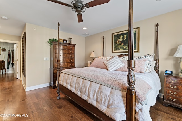 bedroom with ceiling fan, dark hardwood / wood-style floors, a walk in closet, and a closet