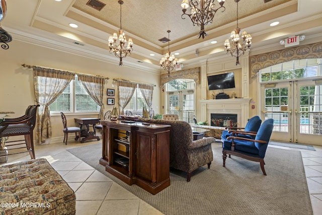 tiled living room with a tray ceiling, crown molding, and french doors