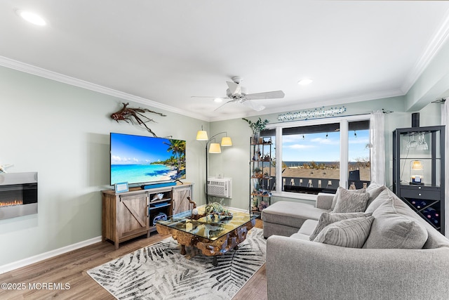 living room featuring ceiling fan, ornamental molding, hardwood / wood-style flooring, heating unit, and a wall mounted air conditioner