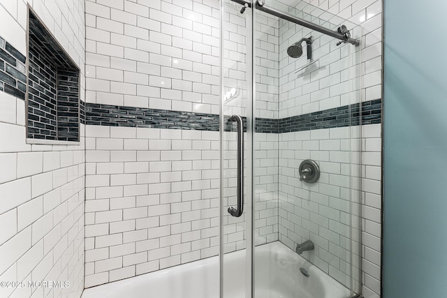 bathroom with combined bath / shower with glass door