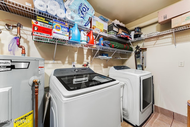 washroom with electric water heater, light tile patterned floors, and washing machine and dryer