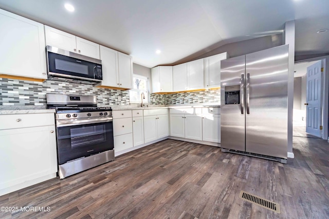 kitchen with dark hardwood / wood-style flooring, sink, appliances with stainless steel finishes, white cabinets, and lofted ceiling