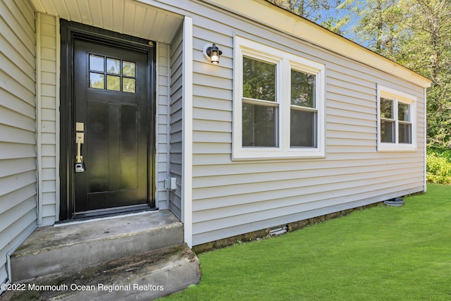 doorway to property with a lawn