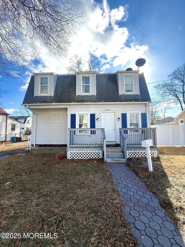 new england style home with a deck and a front lawn