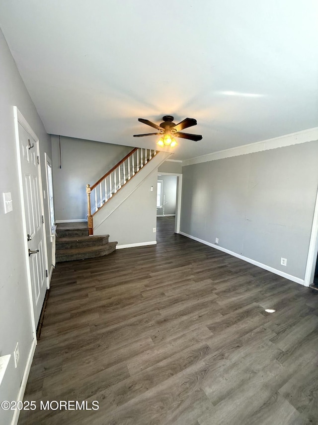 unfurnished living room featuring ceiling fan, dark hardwood / wood-style flooring, and ornamental molding