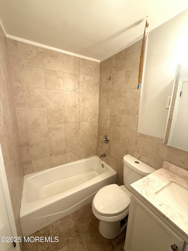 full bathroom featuring tiled shower / bath, tile walls, toilet, tile patterned floors, and vanity