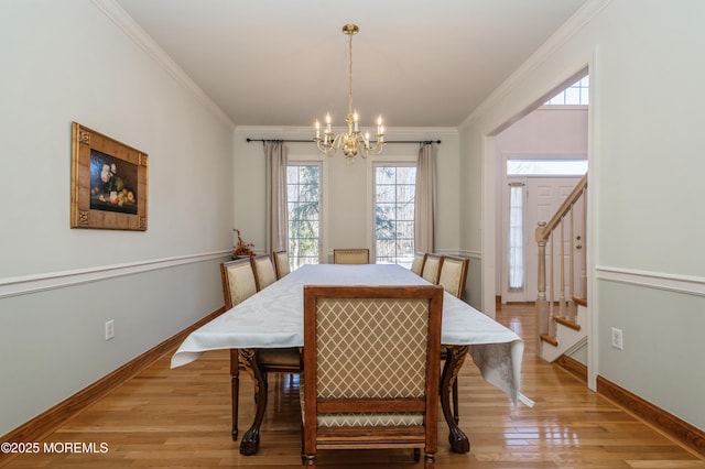 dining room featuring light wood-style floors, baseboards, a chandelier, and crown molding