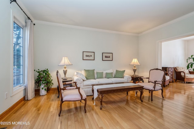 living room with baseboards, crown molding, and light wood finished floors