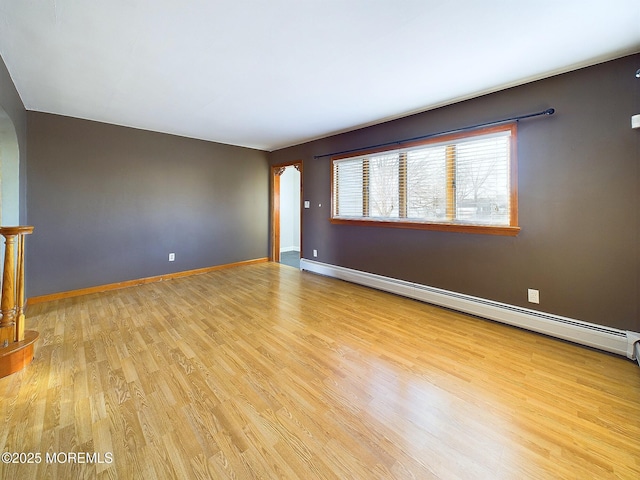 unfurnished living room featuring a baseboard radiator and light hardwood / wood-style floors