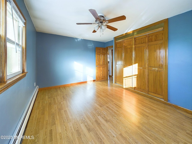 unfurnished bedroom featuring light wood-type flooring, ceiling fan, a closet, and a baseboard radiator