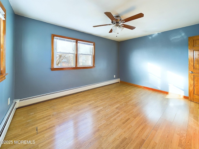 spare room with baseboard heating, ceiling fan, and light wood-type flooring