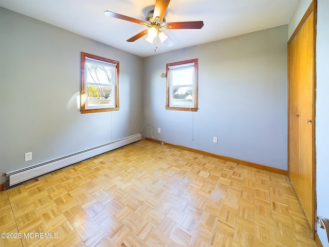 unfurnished room featuring a baseboard heating unit, light parquet floors, and ceiling fan