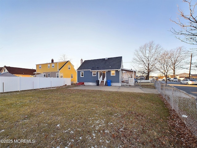 back of house with a patio and a lawn