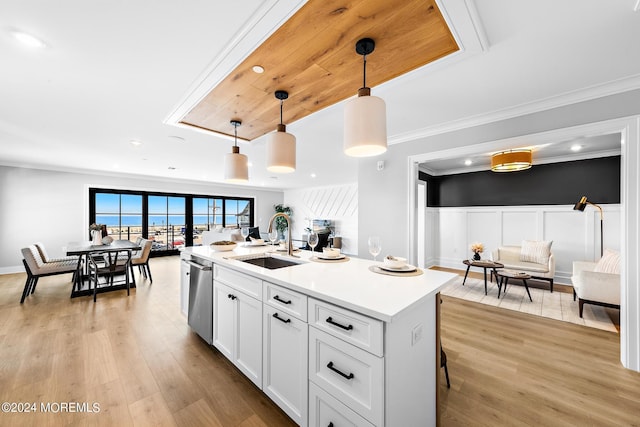 kitchen featuring dishwasher, pendant lighting, light hardwood / wood-style floors, a kitchen island with sink, and white cabinets