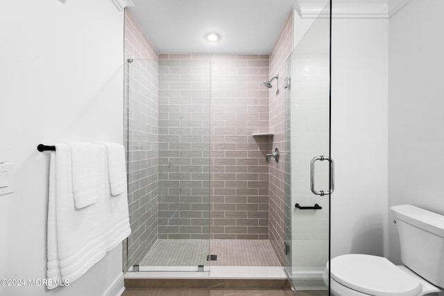 bathroom with toilet and an enclosed shower