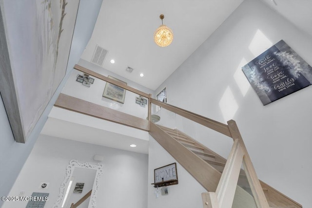 staircase with an inviting chandelier