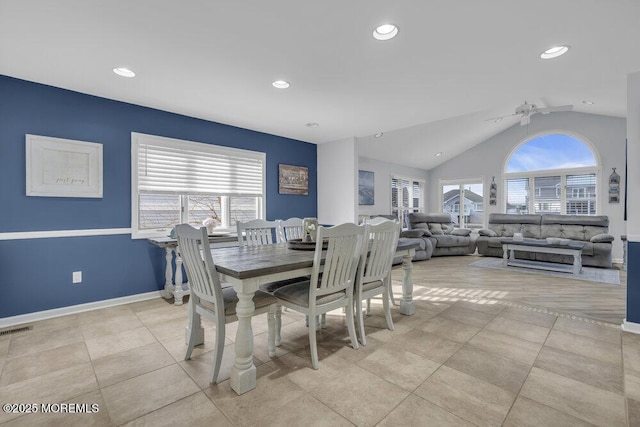 tiled dining space with ceiling fan and lofted ceiling