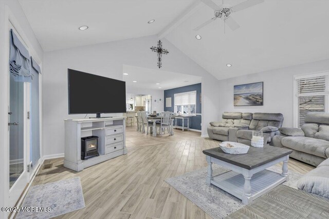 living room featuring beam ceiling, light wood-type flooring, high vaulted ceiling, and ceiling fan