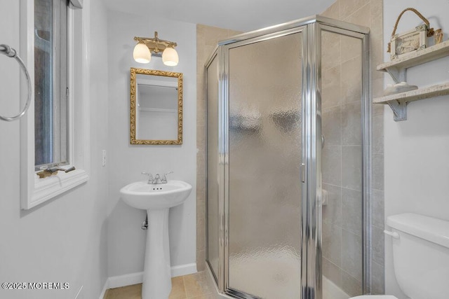 bathroom featuring a shower with shower door, toilet, and tile patterned flooring