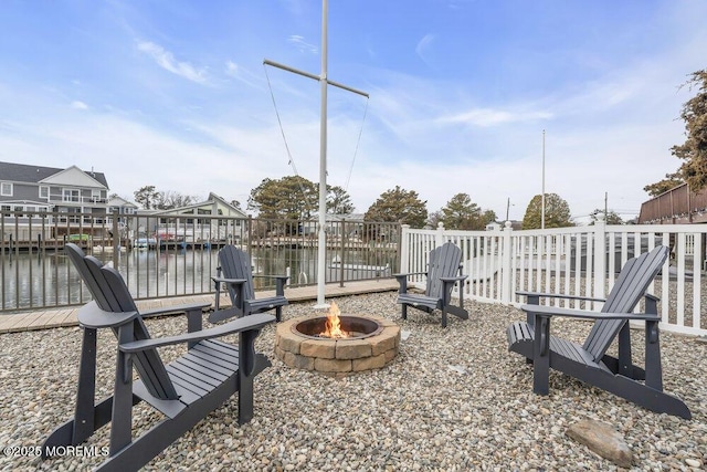 view of patio / terrace with a water view, a boat dock, and a fire pit