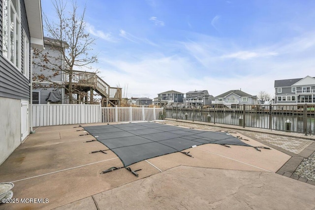 view of pool featuring a water view and a patio