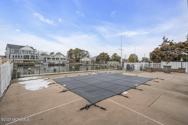 view of swimming pool featuring a water view and a patio