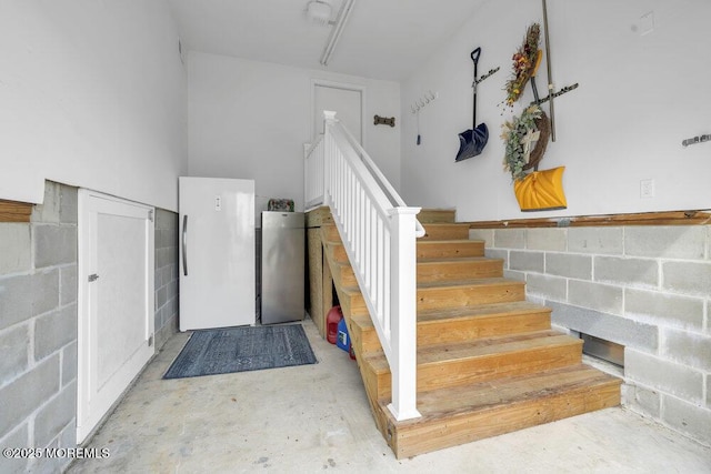 stairs featuring concrete flooring