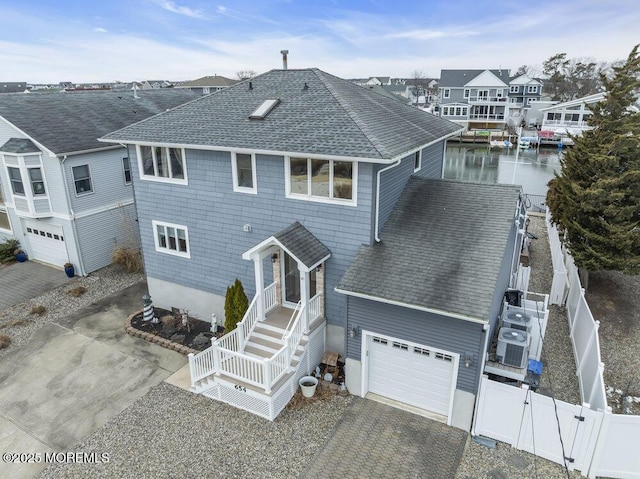 rear view of house with cooling unit and a water view