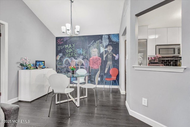 dining area featuring dark hardwood / wood-style flooring, a chandelier, and vaulted ceiling