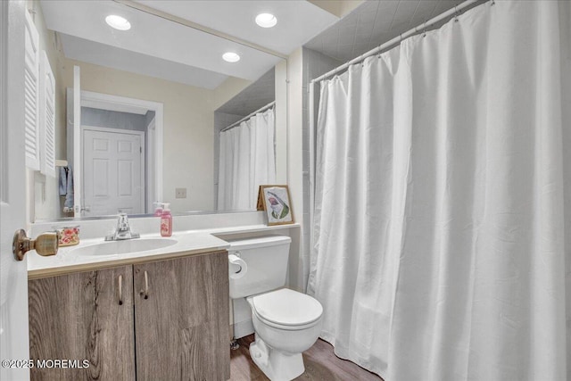 bathroom featuring toilet, vanity, and hardwood / wood-style floors