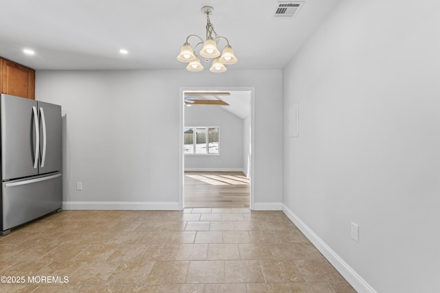 kitchen featuring lofted ceiling, ceiling fan with notable chandelier, stainless steel fridge, and hanging light fixtures