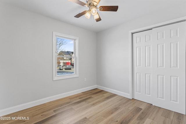 unfurnished bedroom featuring ceiling fan, a closet, and light hardwood / wood-style floors