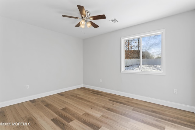 empty room with ceiling fan and light hardwood / wood-style flooring