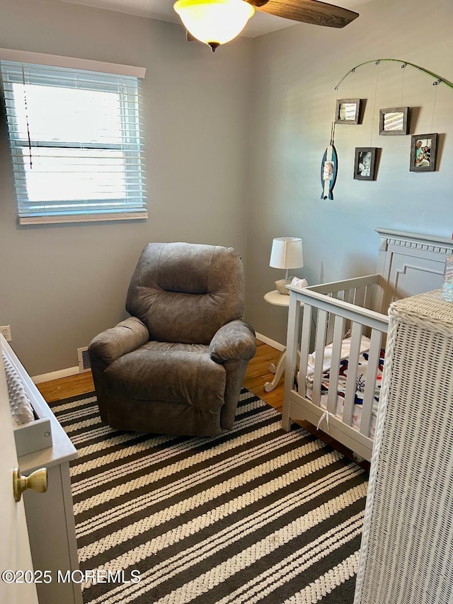 bedroom with hardwood / wood-style floors and a nursery area