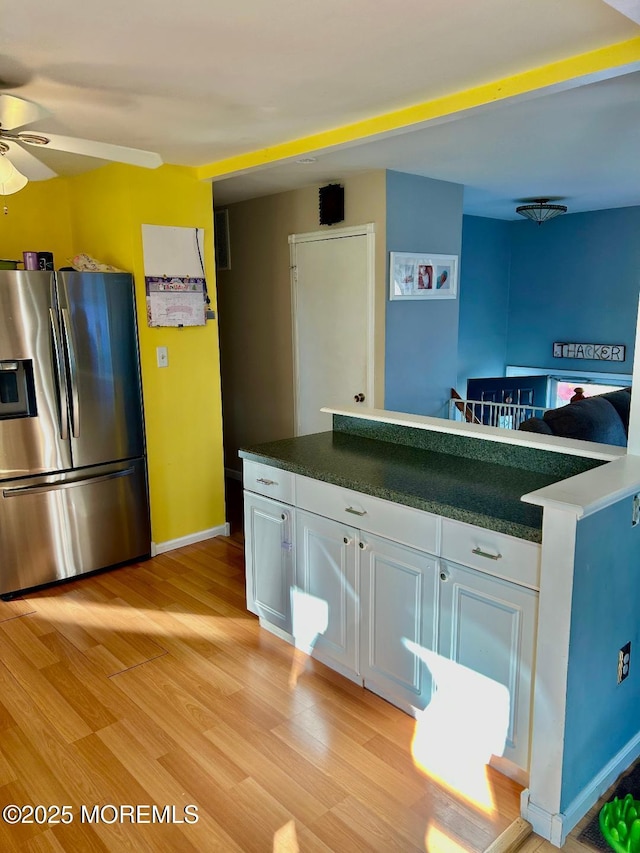 kitchen with stainless steel fridge with ice dispenser, ceiling fan, white cabinetry, and light hardwood / wood-style flooring