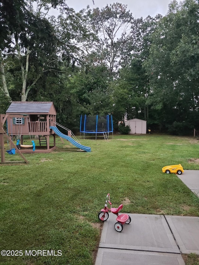 view of yard with a trampoline, a storage unit, and a playground