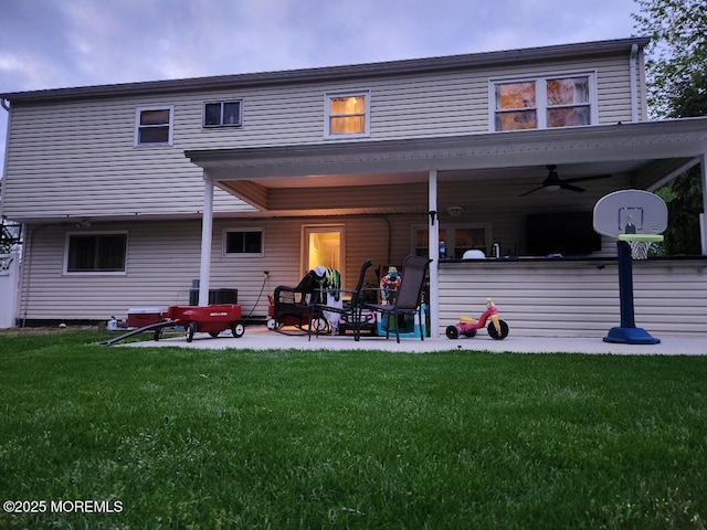 rear view of property with ceiling fan, a lawn, and a patio