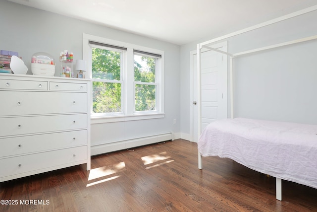 unfurnished bedroom with baseboard heating and dark hardwood / wood-style floors