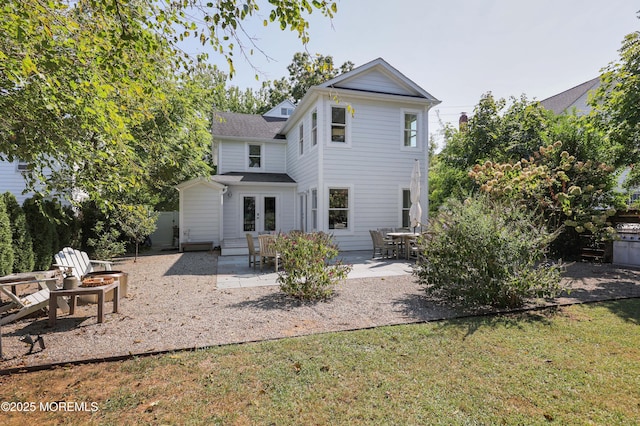 rear view of house with a lawn, french doors, and a patio