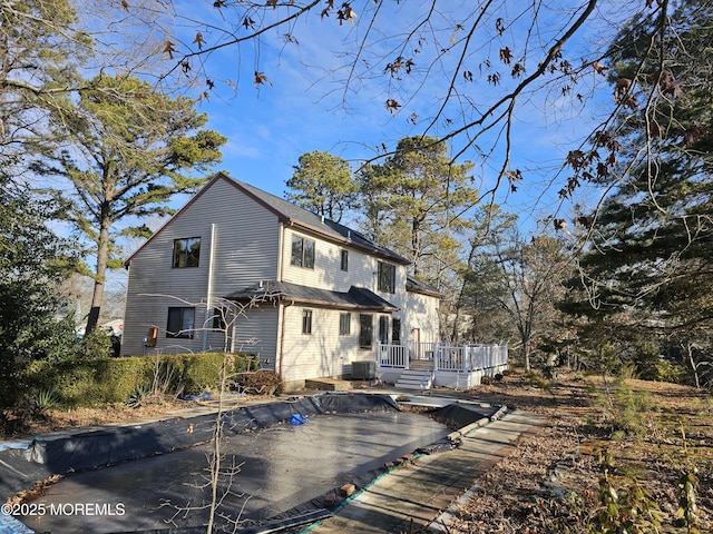 rear view of house with a deck and cooling unit