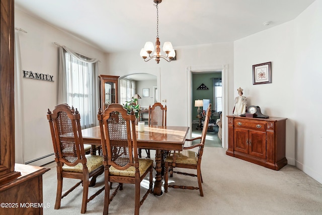 dining space featuring light colored carpet, a baseboard heating unit, and a notable chandelier