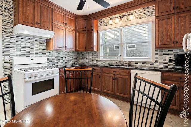 kitchen featuring light tile patterned floors, sink, tasteful backsplash, and white appliances