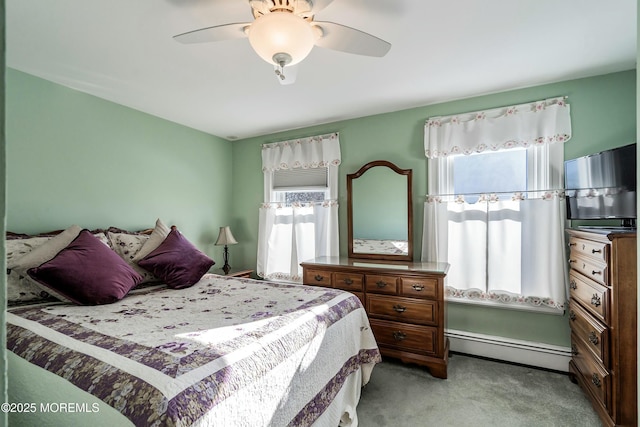 carpeted bedroom featuring ceiling fan and a baseboard heating unit