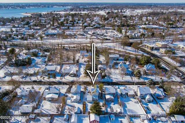 snowy aerial view with a water view