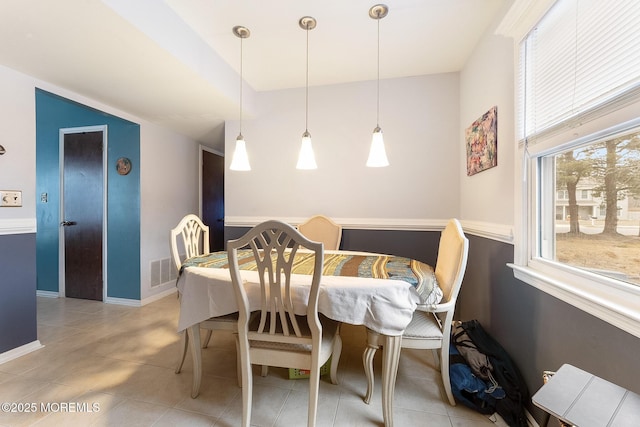 dining area featuring light tile patterned flooring, visible vents, and baseboards