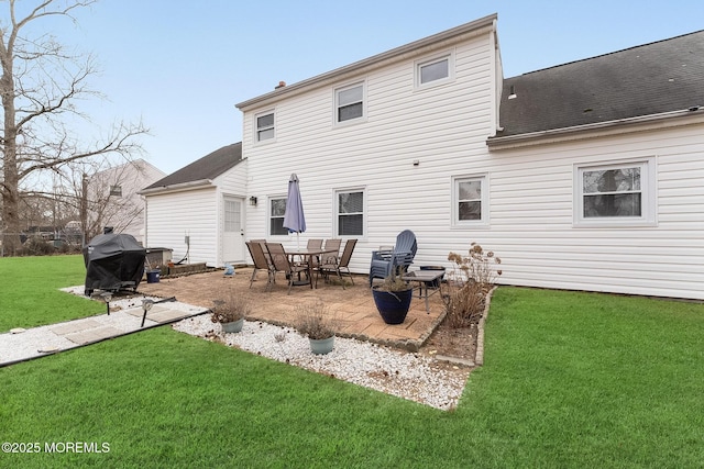 back of property featuring a patio area, a lawn, and roof with shingles